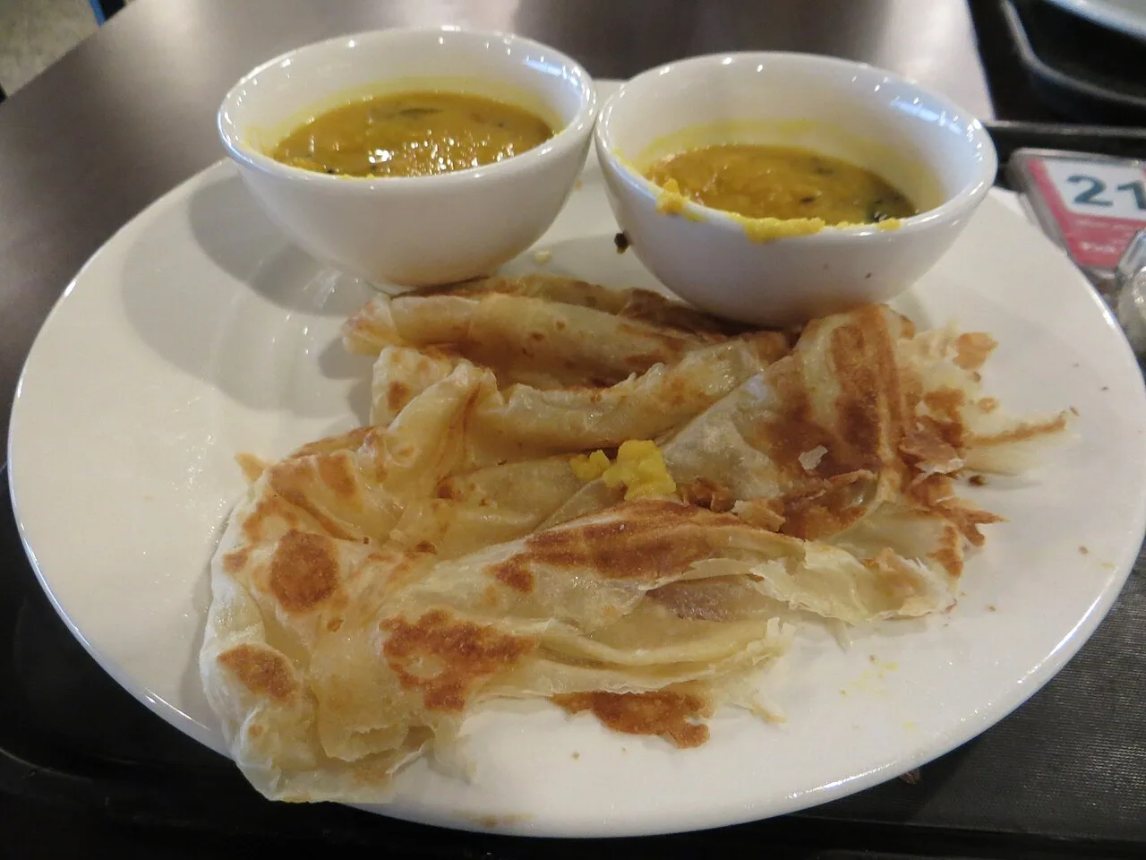 Roti canai flatbread served with dal in Malaysia