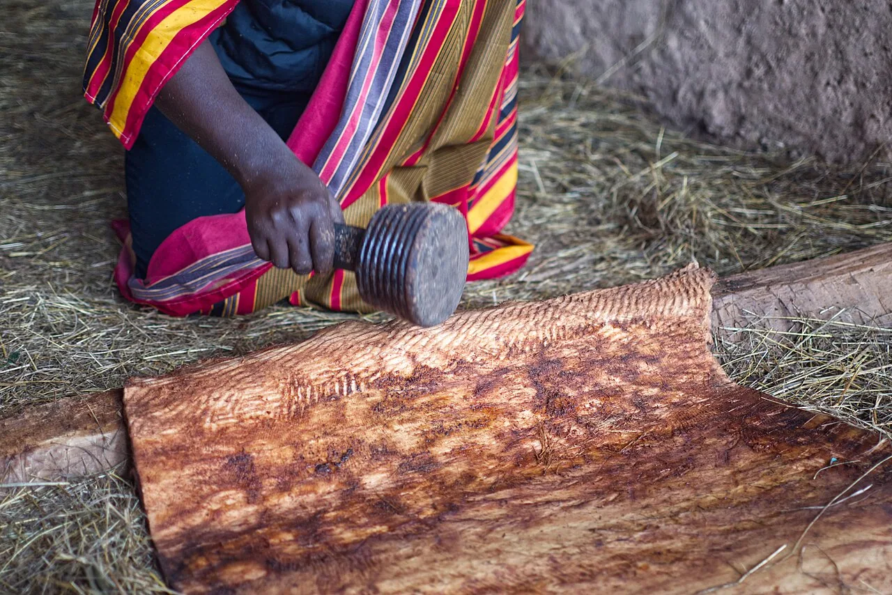 Softening barkcloth with a wooden beater, Uganda