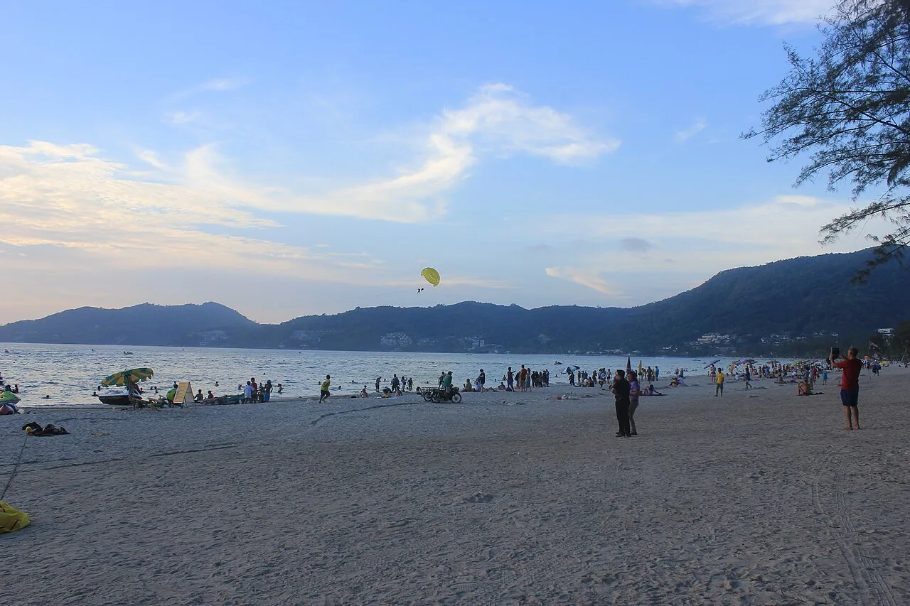 Parasailing over Patong Beach bay at sunset in Phuket
