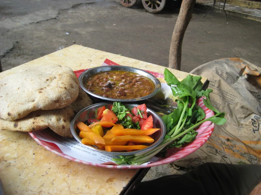 Egyptian ful medames breakfast with bread, pickles and rocket
