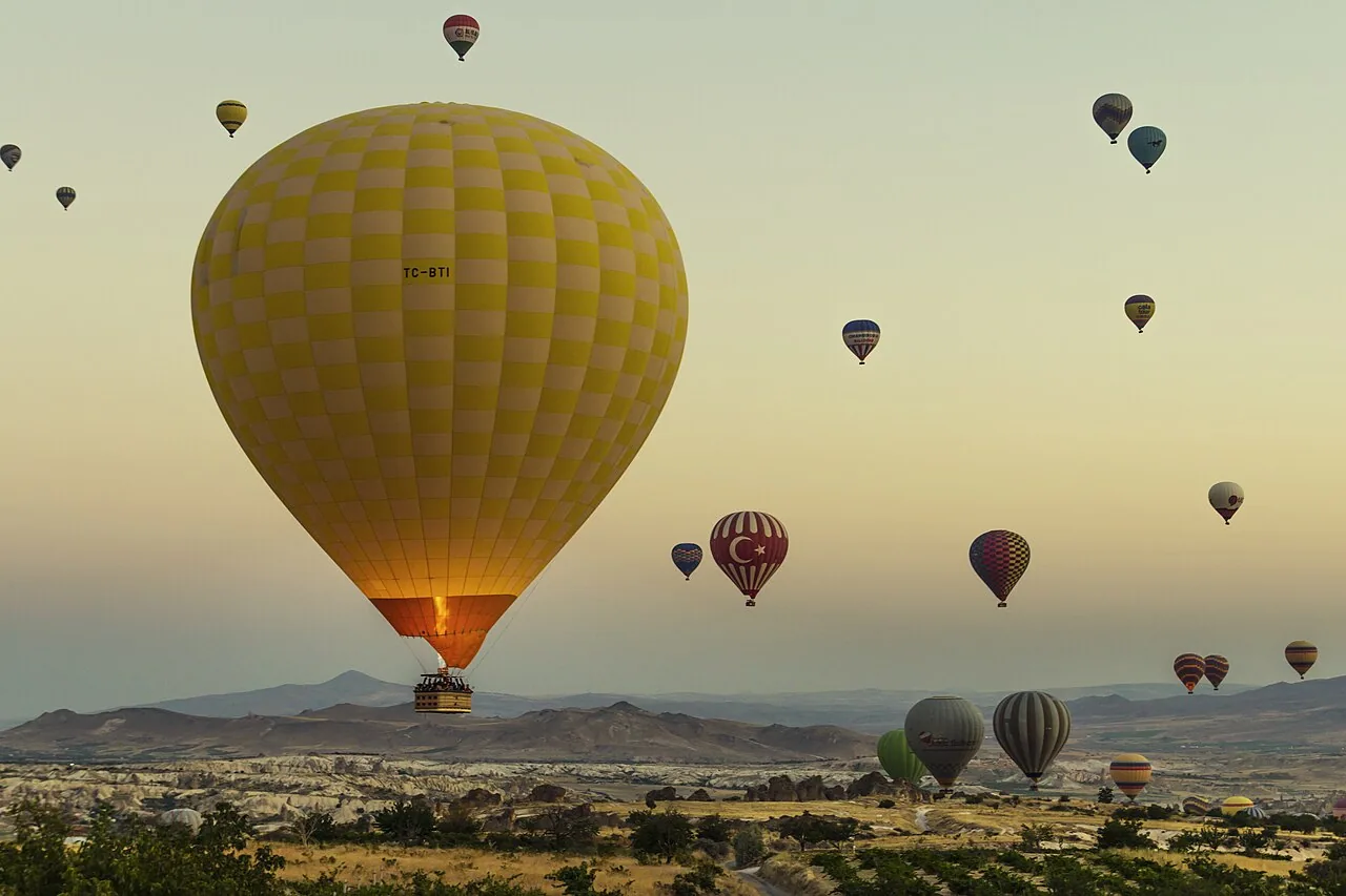 Hot-air balloons rising at sunrise above Göreme, Cappadocia, Turkey